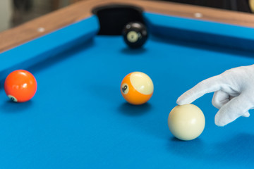 referee hand adjust pool or billiards balls on light blue table