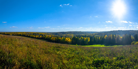 Fototapeta premium Panoramic view of trees of the autumn wood from above, with blue sky, Stone Hill, Mari El, Russia