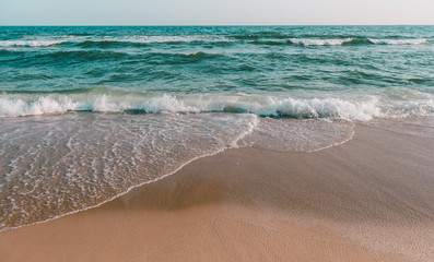 Sea wave and brown sand beach in grey tone.