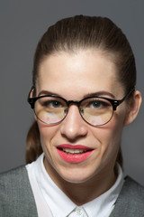 Young beautiful businesswoman or manager in glasses looks at the camera.