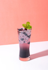 Cold and refreshing  blueberry punch cocktail with mint on color background. summer drink
