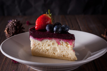 Blueberry cheesecake decorate with pinecorn and dry flower on wood board