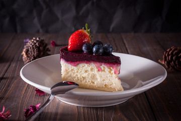 Blueberry cheesecake decorate with pinecorn and dry flower on wood board