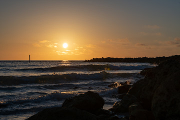 Fototapeta na wymiar sunset view as the waves hit the jetty