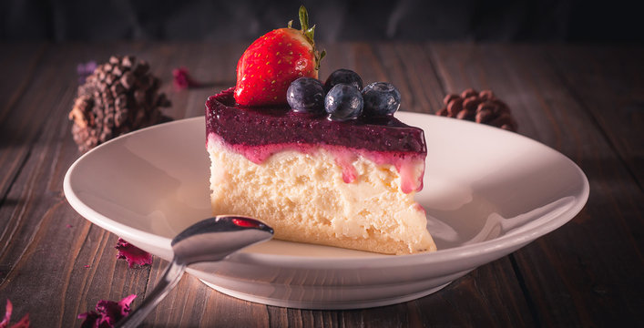 Blueberry cheesecake decorate with pinecorn and dry flower on wood board