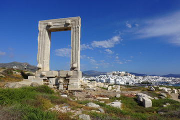 Iconic and unique Temple of Apollon or Portara (Gate) with breathtaking views to port - town and castle of Naxos island and the Aegean blue sea, Cyclades, Greece - obrazy, fototapety, plakaty