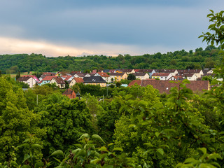 Fototapeta na wymiar View over idyllic village with green landscape and cloudy sky, Neudenau, Baden-Württemberg, Germany.
