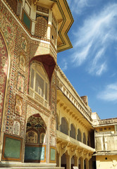 Obraz premium Part of the wall with paintings and carved balcony of the main palace in the ancient Amber fort. Jaipur, India.