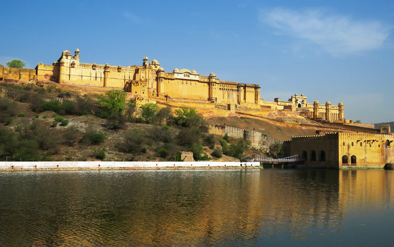 Ancient Amber fort magnificent towering on a rocky hill reflected in the clear waters of the lake. Jaipur, India.