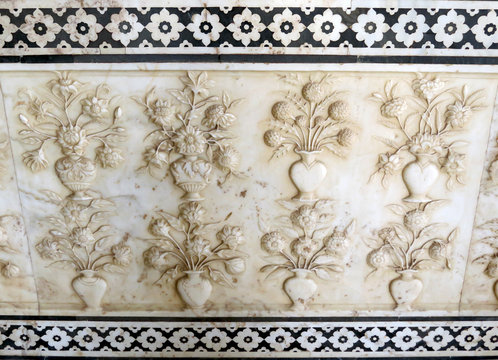 Part of the marble wall with carving in the form of vases with flowers in one of the halls of the ancient palace Shish Mahal, 17th century, in the old Amber Fort, Jaipur, India