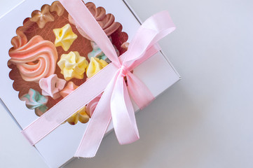 Homemade marshmallows of different colors are beautifully packaged in a gift box. White background. Close-up.