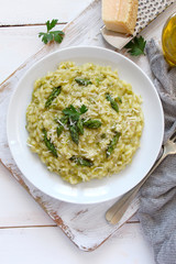 Italian risotto with spring asparagus and parmesan cheese on light background. Top view with copy space.