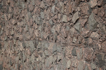 The wall of the building lined with natural stone