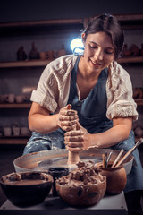 Charming artisan woman working with pottery at the ceramic workshop. Handcraft.