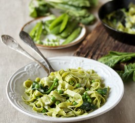 green fettuccine pasta with spinach leaves and green peas. ready meals, vegetarian cuisine. Italian food. square format