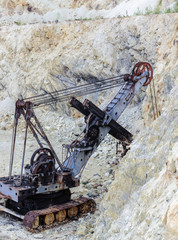 Rusty, abandoned quarry excavator, in Roșia Montană, Romania. Vintage Mining Equipment. 