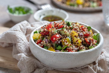 Fresh quinoa tabbouleh salad with tomatoes, peppers and cucumbers