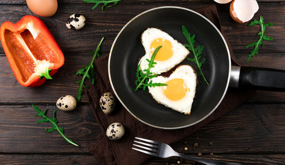 fried eggs in the form of a heart in a skillet.