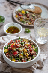 Fresh quinoa tabbouleh salad with tomatoes, peppers and cucumbers