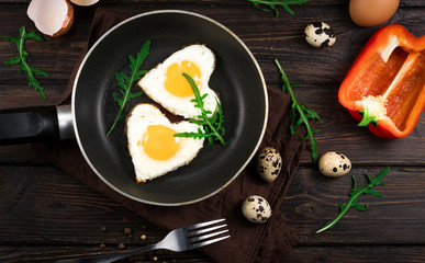 fried eggs in the form of a heart in a skillet.