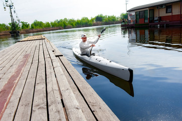 Male oarsman canoeing on lake using paddle in summer day © serguastock