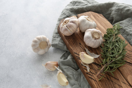 garlic and rosemary on a wooden board
