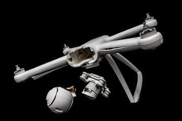 Broken white drone after a fall. Isolated on a black background. Damaged body, motor and stabilizer camera gimbal