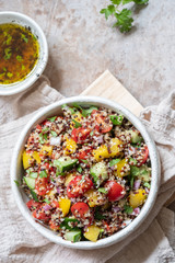 Fresh quinoa tabbouleh salad with tomatoes, peppers and cucumbers