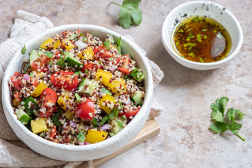 Fresh quinoa tabbouleh salad with tomatoes, peppers and cucumbers