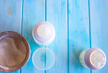 Composition with feeding bottle of baby milk formula on wooden table