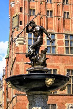 The Neptune, bronze statue of the Roman God of the Sea (Poseidon in Greek mythology) located in the Old Town of Gdansk, Poland. Old Town building in the background