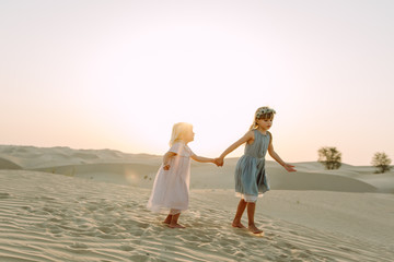 Two little beautiful girls in the desert in Dubai