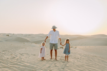 Young father having fun with his daughters in the desert