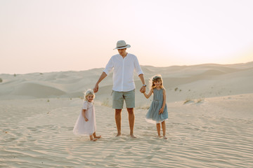 Young father having fun with his daughters in the desert