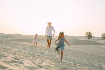 Father with two daughters in the desert in Dubai