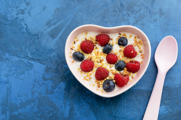 Morning Healthy Dairy Delicious Meal Top View. Spoon near Organic Vegetarian Dessert Greek Yoghurt with Raspberry, Blueberry and Grains of Seed in Ceramic Plate. Creamy Vitamins Breakfast
