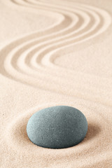 Stone meditation garden. Japanese zen concept for buddhism and mindfulness. Concept for concentration and fucusing. Round rock on sandy background with copy space.