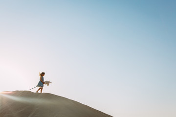 Little girl playing with a horse toy in the desert in Dubai
