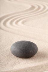 Fototapeta na wymiar Zen garden with raked sand and round meditation stone for concentration and focus. Concept for balance, harmony and purity in Yoga mindfulness and buddhism.