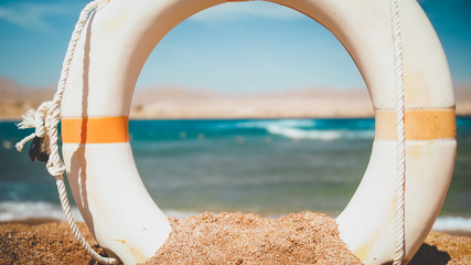 Closeup image of beautiful sea beach and white plastic kife saving ring at bright sunny day....