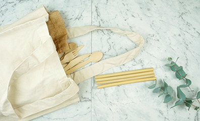 Fototapeta na wymiar Zero-waste, plastic-free tableware flatlay overhead with bamboo and natural fibers to replace single use plastic products.