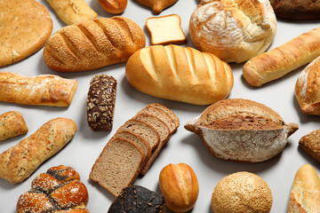 Different kinds of fresh bread on light background