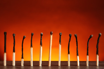 Whole match among burnt ones on table against color background. Uniqueness and difference concept