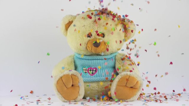 plush toy bear on a white background with a colorful confetti