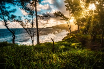 View of the wild south coast of Reunion Island at sunset where the waves break on the basalt rocks - touristic site