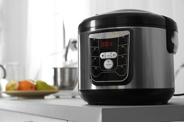 Modern multi cooker on table in kitchen. Space for text
