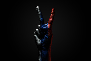 A hand with a drawn Russia flag shows an PEACE sign, a symbol of peace, friendship, greetings and...