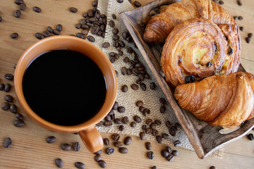 Słodkie śniadanie: czarna kawa, croissant i bułka z rodzynkami - obrazy, fototapety, plakaty