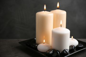 Plate with color candles and rocks on table, space for text