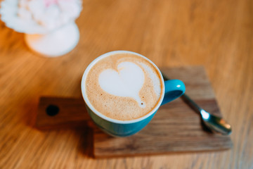 Latte hot coffee in a green cup with latte art